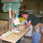 David aligns and drills holes in a cabinet component at Cascade Casework in Albany OR